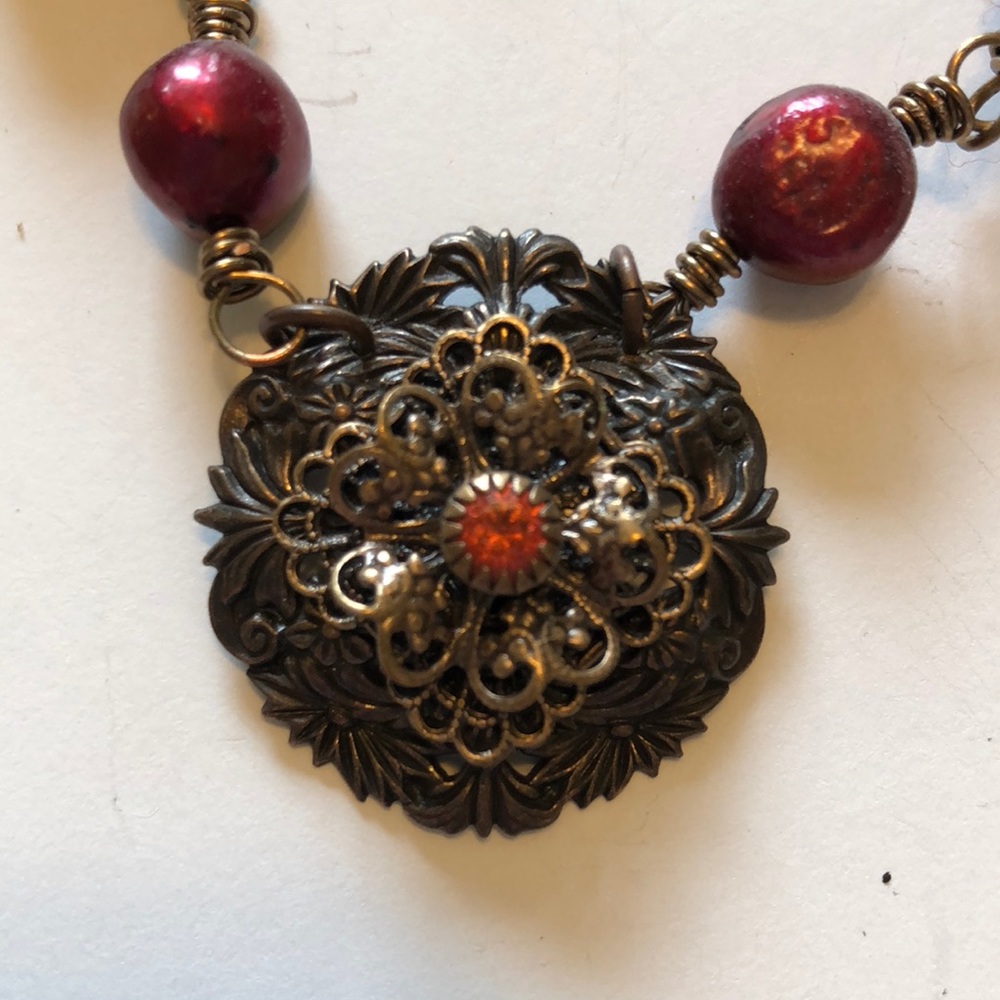 Artisan necklace with red accents.